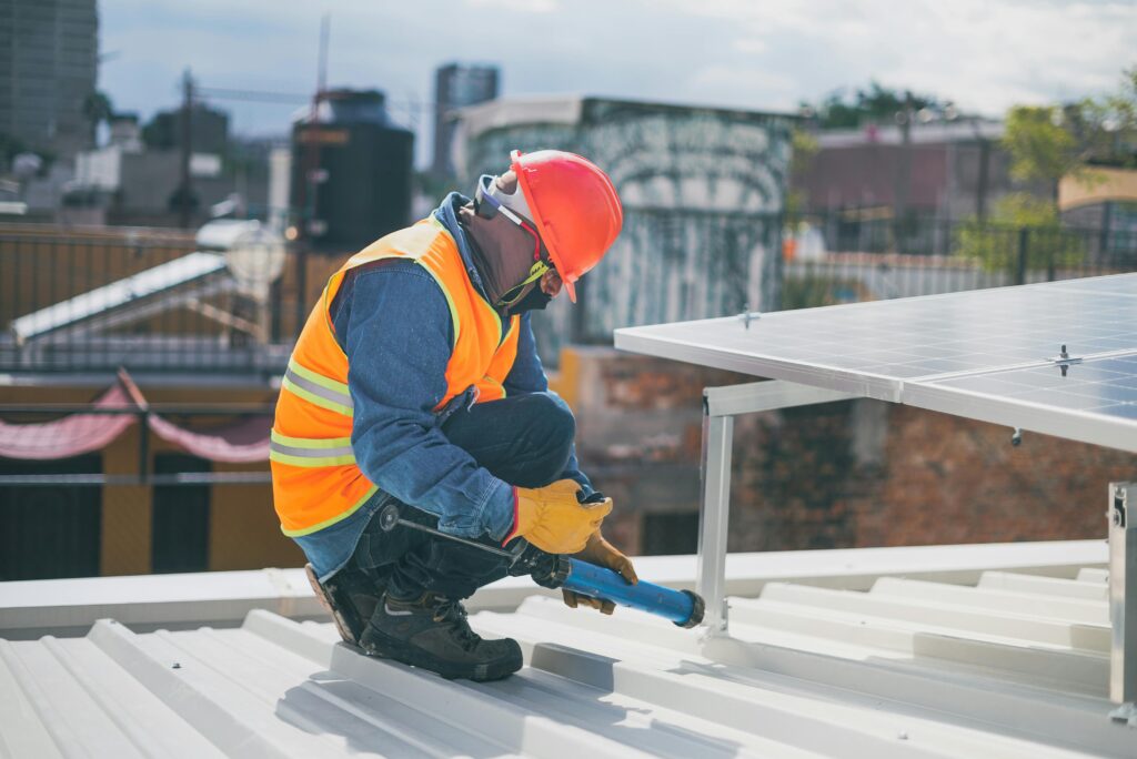 pexels photo 8853534 8853534 Technician in safety gear installing solar panels on a rooftop, ensuring energy efficiency.